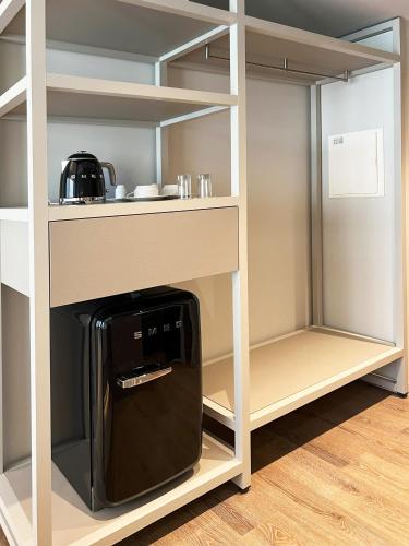 una cucina con macchinetta del caffè in un armadio di Oca Bom Sucesso Hotel a Porto