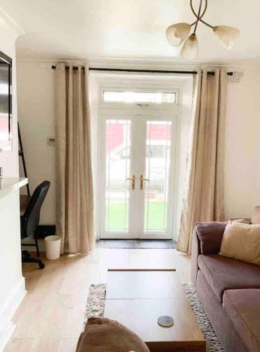 a living room with a couch and a door at Lovely Two Bedroom Apartment, with private garden! in Torquay