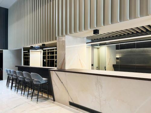 a lobby with a bar with stools at Oca Bom Sucesso Hotel in Porto