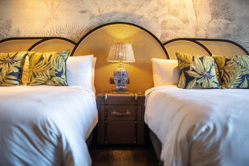 a bedroom with two beds and a lamp on a night stand at Hualien Farglory Hotel in Yanliau