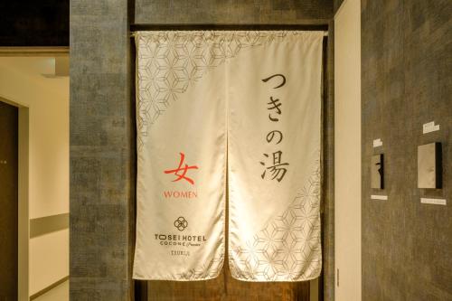 a banner on a door with a sign on it at Tosei Hotel Cocone Tsukiji Ginza Premier in Tokyo