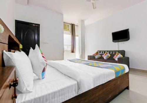 a bedroom with a large bed and a television at HOTEL THE LAZEEZ in New Delhi