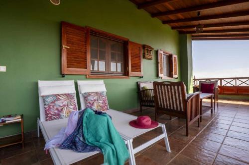 ベガ・デ・サン・マテオにあるCasa Rural Gran Canaria El Cañaveralの緑の壁の客室で、テーブルと椅子が備わります。