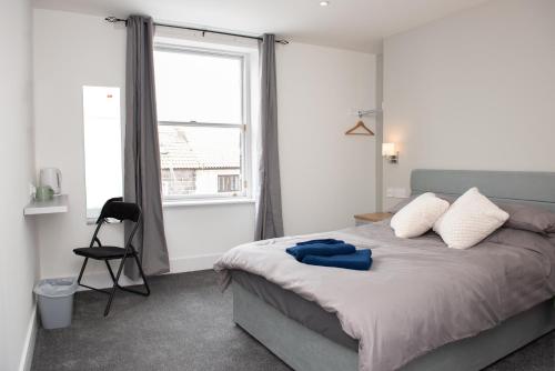 a bedroom with a large bed and a window at Cara Lodge, Comfortable Self Check-in En-suite Guest Rooms in Berwick-Upon-Tweed