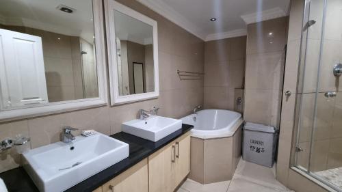 a bathroom with two sinks and a toilet and a shower at Accommodation Front - Dazzling 4 Sleeper near Ushaka Marine World in Durban