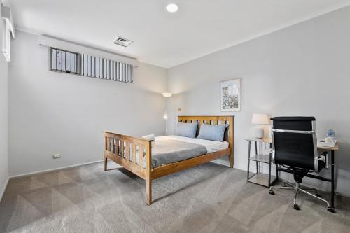 a bedroom with a bed and a desk and a chair at Super nice house with sea view free parking in Sandy Bay