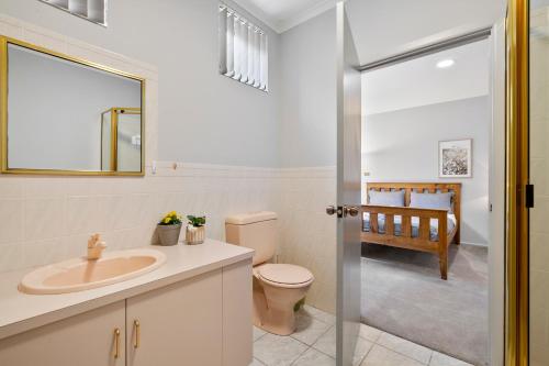 a bathroom with a sink and a toilet and a mirror at Super nice house with sea view free parking in Sandy Bay