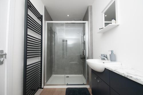 a bathroom with a shower and a white sink at Cara Lodge, Comfortable Self Check-in En-suite Guest Rooms in Berwick-Upon-Tweed