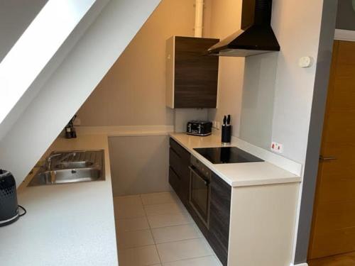 a kitchen with a sink and a counter top at Two Bedroom Duplex Apartment The Priory in St Ives