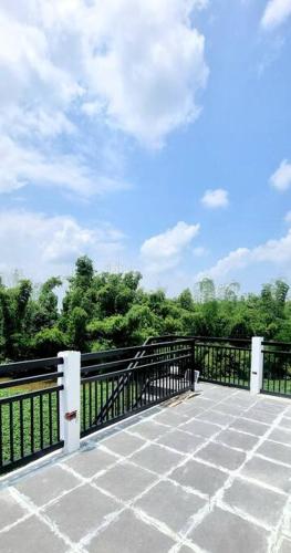 a balcony with a black fence and trees at Riverfront Residence in San Carlos, Pangasinan 