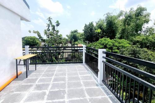 a balcony with a wooden table and a fence at Riverfront Residence in San Carlos, Pangasinan 