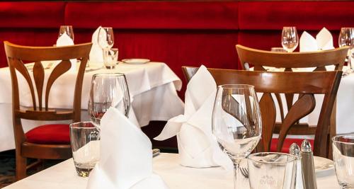 a table in a restaurant with glasses and napkins at Victor's Residenz-Hotel Leipzig in Leipzig