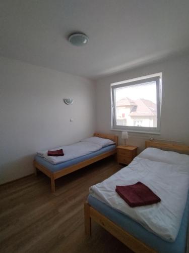 a bedroom with two beds and a window at Turistická ubytovňa Hornád in Spišské Tomášovce