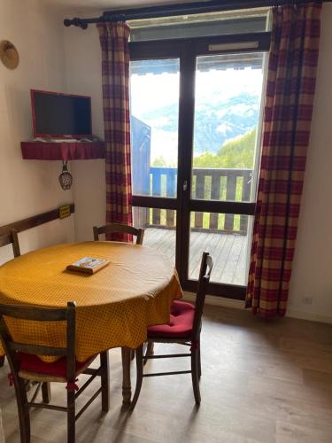 une salle à manger avec une table et des chaises et une grande fenêtre dans l'établissement Pra Chauvet 107, à Uvernet