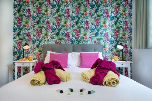 a bedroom with a bed with pink and yellow pillows at Luxury Country Cottage, near Tavistock. in Tavistock