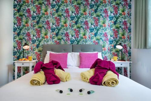 ein Schlafzimmer mit einem Bett mit rosa und gelben Kissen in der Unterkunft Luxury Country Cottage - Apple Pie Luxury Escapes in Tavistock