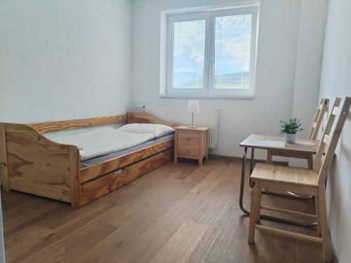 a bedroom with a bed and a table and a chair at Turistická ubytovňa Hornád in Spišské Tomášovce