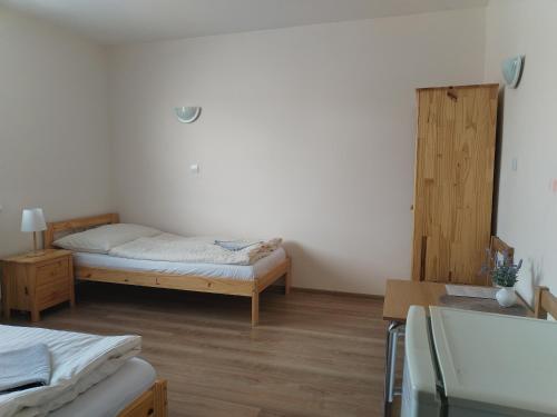 a room with a bed and a desk and a bed and a table at Turistická ubytovňa Hornád in Spišské Tomášovce