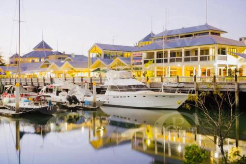a marina with boats docked in front of a building at Paradise Escape - Poolside Ground Floor - Sea Temple Resort and Spa in Port Douglas