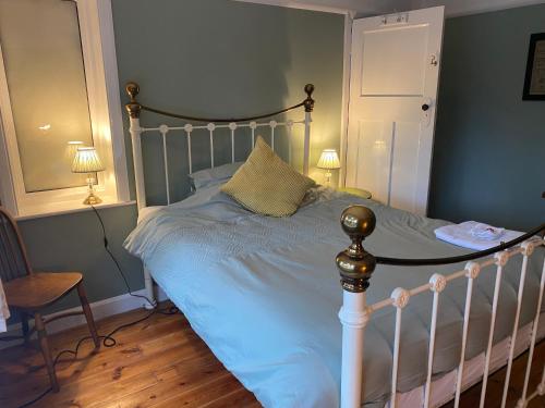 a bedroom with a bed with blue sheets and two lamps at Double & Single Room Horley near Gatwick in Horley