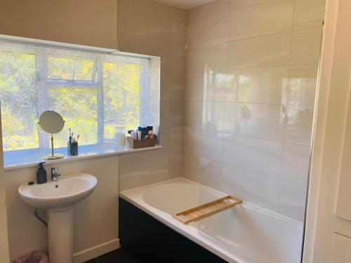 uma casa de banho com um lavatório e uma banheira e um lavatório em Double & Single Room Horley near Gatwick em Horley