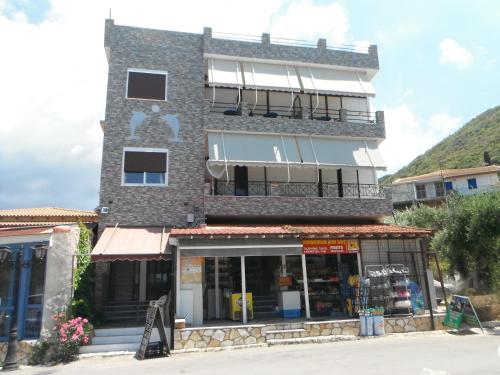 a building with a store in front of it at Orfeas Rooms in Vasiliki