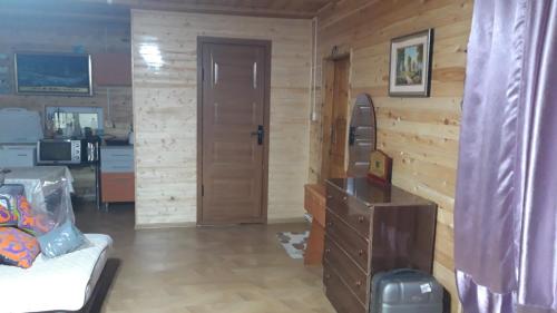 a living room with wooden walls and a door at Tiny house in Ulgii in Ölgiy
