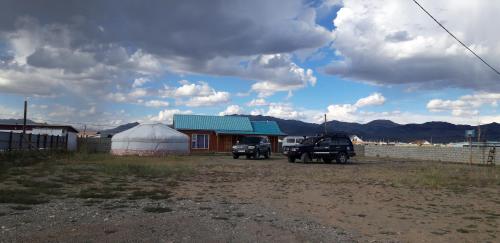 two trucks parked in front of a white tent at Tiny house in Ulgii in Ölgiy