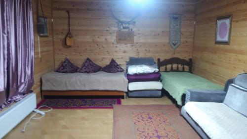 Habitación pequeña con 2 camas y sofá en Tiny house in Ulgii en Ölgiy