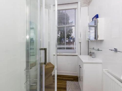 a white kitchen with a window and a sink at Pass the Keys Lovely flat near Belsize Park, North Central London in London