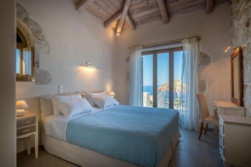 a bedroom with a large bed and a large window at Extravagant Zante Villa Villa Harmonia Great Sea Views 4 Bedrooms Agios Nikolaos in Koríthion