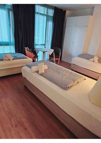 a bedroom with three beds and a table and chairs at Estelada Hostel Berg am Laim in Munich