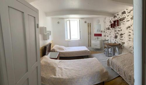 a bedroom with two beds and a desk and a window at maison de village in Ax-les-Thermes