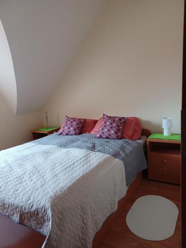 1 dormitorio con 1 cama grande con almohadas moradas en T-Apartman Hajdúszoboszló, en Hajdúszoboszló