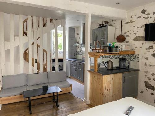 a living room with a couch and a kitchen at maison de village in Ax-les-Thermes
