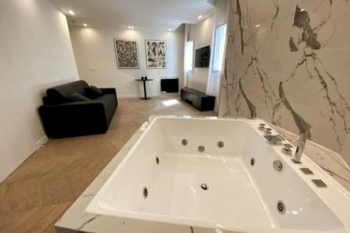 - une grande baignoire blanche dans le salon dans l'établissement Love Room Luxury Jaccuzi, à Saint-Maurice