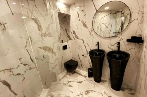 - une salle de bains avec deux poubelles et un miroir dans l'établissement Love Room Luxury Jaccuzi, à Saint-Maurice