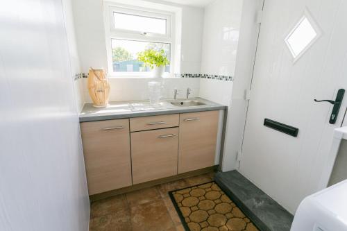 a bathroom with a sink and a window at Cwter Hywel in Coedana