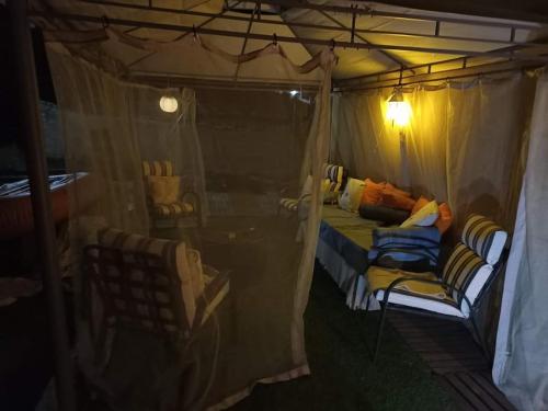 Zimmer mit einem Bett und Stühlen in einem Zelt in der Unterkunft MiniCasa con vistas a las Hoces del río Riaza. in Montejo de la Vega de la Serrezuela