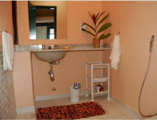 a bathroom with a sink and a mirror at Casa Angra Itanema in Angra dos Reis