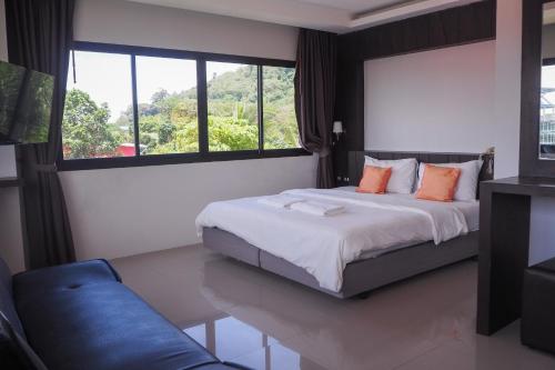 1 dormitorio con cama y ventana grande en Rakkawan Residence - SHA EXTRA PLUS en Khao Lak