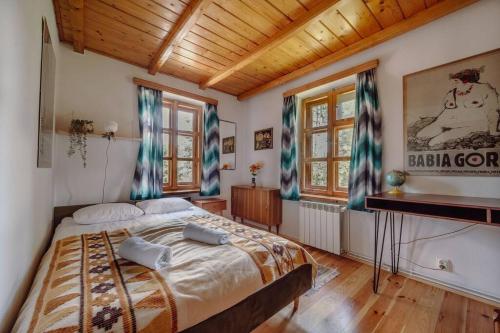Un dormitorio con una cama grande en una habitación con techos de madera. en Willa Juszczyn, en Juszczyn