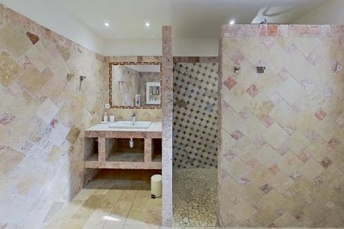 une salle de bain avec un lavabo et un miroir dans l'établissement Villa La Chiappa Bord de Mer avec piscine chauffée et Jacuzzi, à Porto-Vecchio