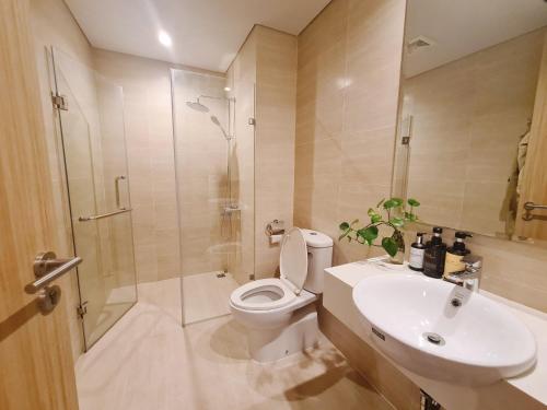 y baño con aseo, ducha y lavamanos. en By's House Căn hộ view vịnh Hạ Long en Ha Long