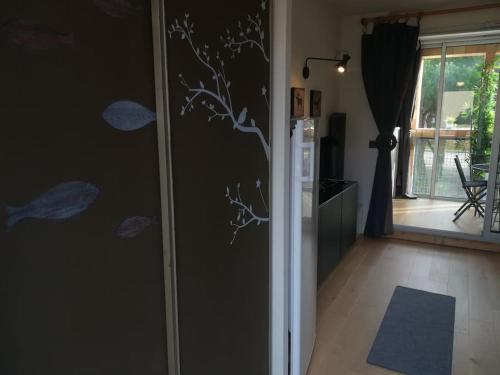 una sala de estar con una pared con ramas y hojas pintadas en APPARTEMENT HOURTIN PLAGE ET PORT en Hourtin