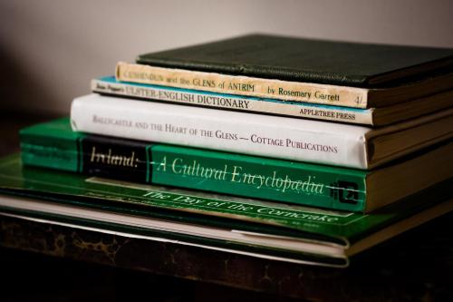 a stack of books sitting on top of a table at Number 19 Heart Of The Glens in Cushendall