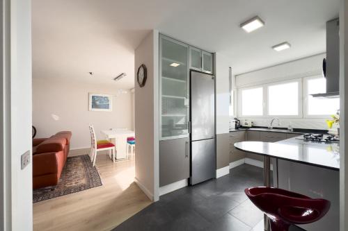 a kitchen with a refrigerator and a dining room with a table at Impresionante Apartamento delante del Mar in Vilassar de Mar