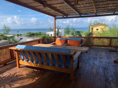 a wooden bench on a deck with a view of the ocean at Eco Lagoon in Phu Quoc