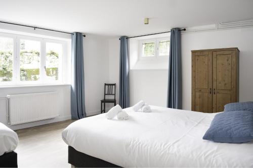 une chambre avec deux lits et deux fenêtres dans l'établissement Villa Pax 1 et 2 La Bourboule, à La Bourboule