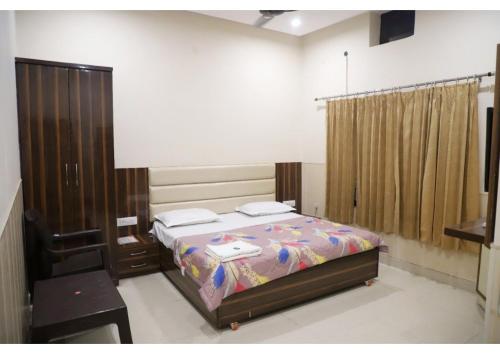 a bedroom with a bed and a chair in it at Rk Lodge in Amritsar